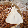 small plain muslin pouch closed with drawstring with loose soapnuts in basket and on ground