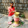 girl kneeling next to painted Daily Dump Pooja Rangoli flower waste compost bin decorated with flowers