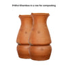 Pair of Daily Dump Prithvi Khambas home composters in outdoor garden with young girl adding kitchen waste to one.