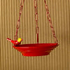 Yellow Bird feeder hanging 3 D against corrugated background