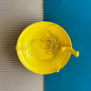 Yellow Bird feeder hanging 3 D against corrugated background