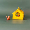 Red hanging metal birdhouse with chain with sparrow in outdoor garden