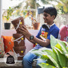 Young man putting bowl of kitchen waste in Daily Dump Gobble solo home composter by indoor window sill and saving 25kg from landfill every year