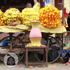 girl kneeling next to painted Daily Dump Pooja Rangoli flower waste compost bin decorated with flowers